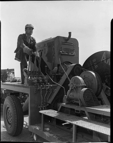 Man at controls of conductor pulling machine