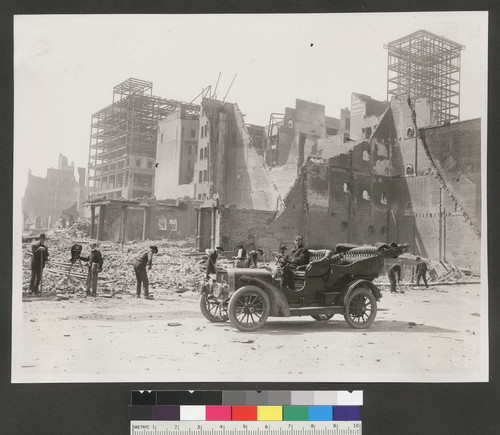 [Man in car parked near ruins. Unidentified photographer at left. Frames of Newman & Levinson and Whittell buildings (near Union Square) in background. From near Grant, O'Farrell and Market Sts.?]