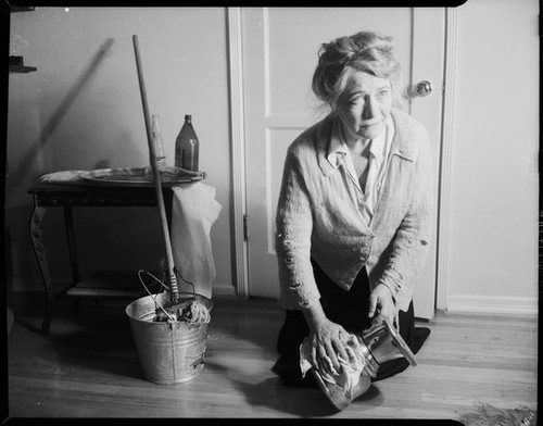 Mrs. Flournoy, in cardigan with holes, polishing bowl, [1950s]