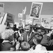 Presidential candidate Eugene McCarthy surrounded by a large crowd at a campaign rally