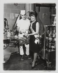 California Dairy Princess at Clover Dairy with a dairy worker at the cottage cheese packing machines, Petaluma, California, 1966