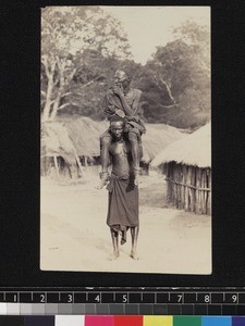 Man carrying chief on shoulders, Africa, ca. 1900