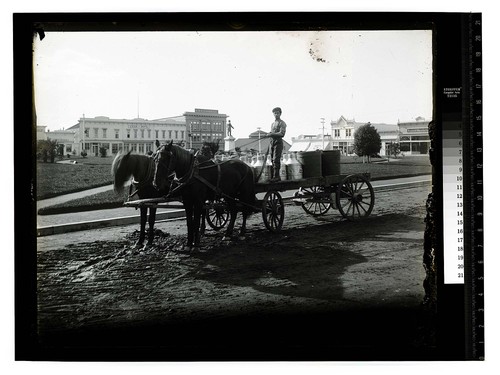 [Two horse team pulling a wagon load of milk cans and tubs]