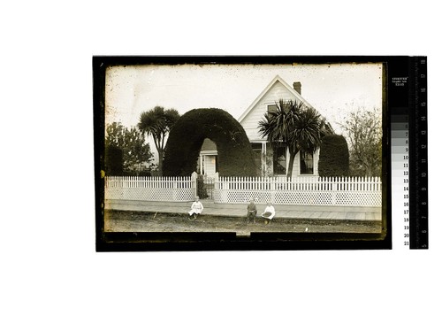 [Three Ericson children pose on wooden sidewalk in front of the family home]