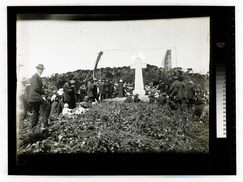 [Large well dressed crowd gathered at a large cross on a