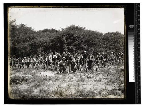 [Many men pose with theirBicycles in a rural setting]