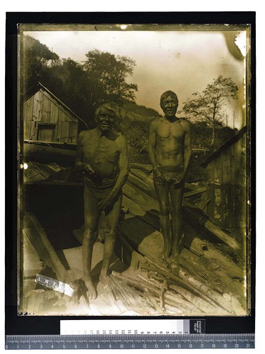 [Two men posing at entrance of a sweat house]