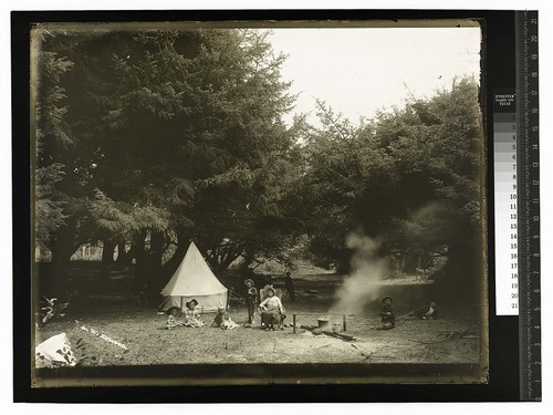 [A family relaxing at a rustic campsite]