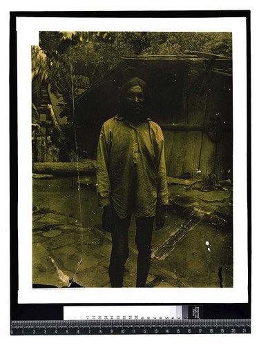 [Elderly man at Pecwan Creek in front of traditional house]