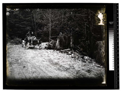 [A couple in an open auto on a country road]