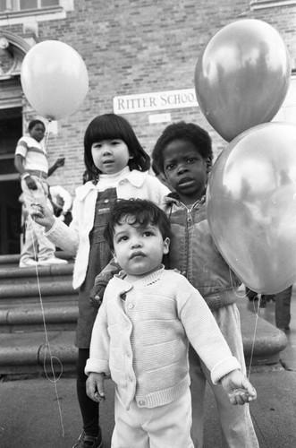 Children holding balloons at Ritter Elementary School, Watts (Los Angeles, Calif.), 1983