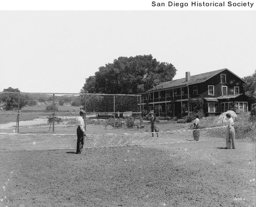 Four people playing tennis at the Campo Hotel