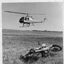California Highway Patrol helicopter hovering over crashed motorcycle in a field