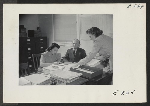 The Superintendent of Schools, A. G. Thompson, on a busy morning in his office. (L to R) Miye Magota, stenographer; A. G. Thompson, Superintendent of Schools; Ida Mae Clark, Secretary to the Sup't. Photographer: Parker, Tom Denson, Arkansas