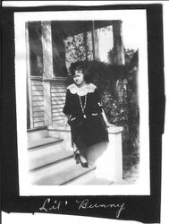 Bunni Cornelia E. Myers seated by front steps of house