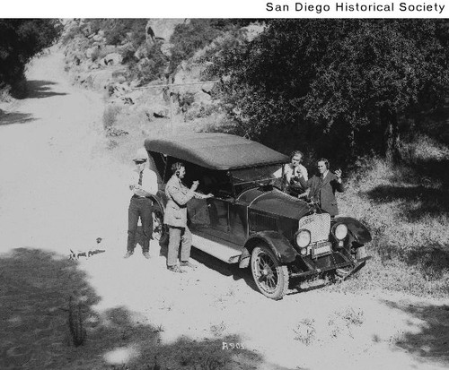 Four men on National Auto Radio Trip standing around an automobile