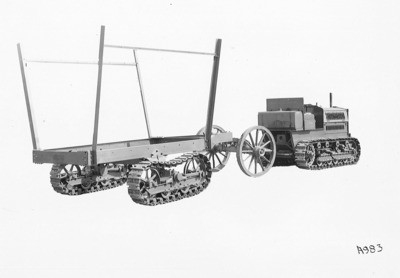 Crawler Tractors - Stockton: Caterpillar tractor towing a trailer equipped with caterpillar tracks