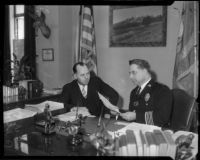 Chief of the L.A.P.D. James E. Davis speaks with Capt. William F. Hynes in his office, circa 1934