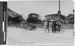 Men pulling a cart filled with baskets, Hong Kong, China, ca.1920