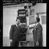 Kenneth Hahn and unidentified man demonstrating "talking" cross-walk traffic signal in Los Angeles, Calif., 1965