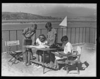 Jim Sherry, Joan Sherry, John David, and Tony Brackett working on their newspaper, Newport Beach, 1935J