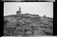 Man at top of rock formations at Red Rock Canyon State Park, California, circa 1920-1930