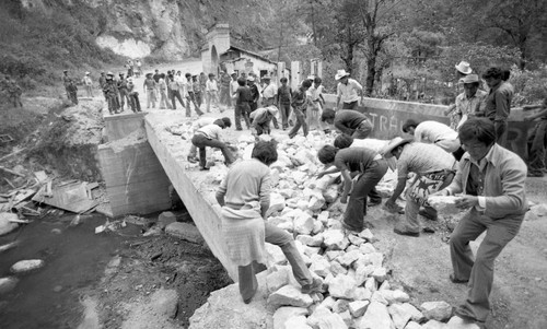Civilians cleaning up rubble from a crumbling bridge, Chichicastenango, 1982