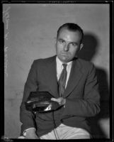 Thomas R. Warren displays his invention, a hand-held ultra-violet lamp, Pomona, 1933