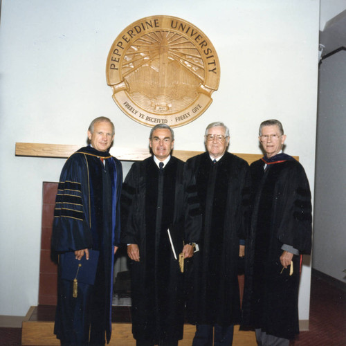 Dean Wilburn, Robert Hood, Ross Blakely, and Chancellor Runnels beneath the Pepperdine University seal