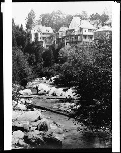 View of a river showing a series of housing structures in Northern California, ca.1900