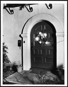 Decorated door hung with a wreath, ca.1920-1929