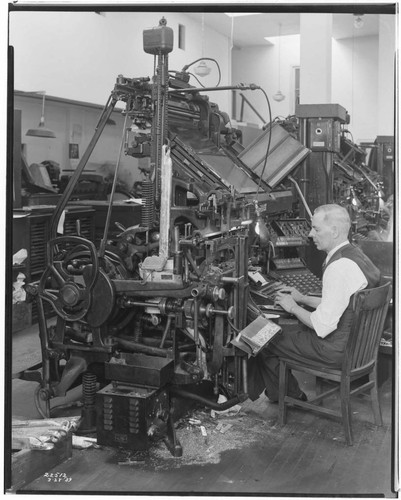 Man typing at Linotype machine in the Huntington Park Signal pressroom