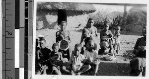 Group portrait of people sitting together outside, Africa, January 1947