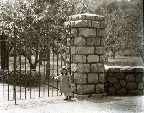 Unidentified child near the gate and drive of the Bach family estate in Kentfield, Marin County, California, circa 1902 [photograph]
