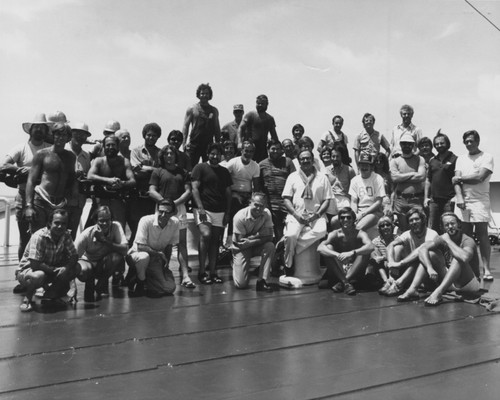 Scientists, technicians, and all other crew members pose with Joe Clarke (center - kneeling with folded arms), the captain of the D/V Glomar Challenger (ship), for the traditional crew photo taken aboard the ship during one of the legs of the Deep Sea Drilling Project. 1979