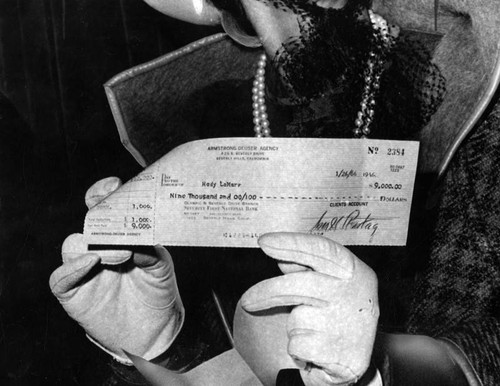 Hedy Lamarr displays check for $9000
