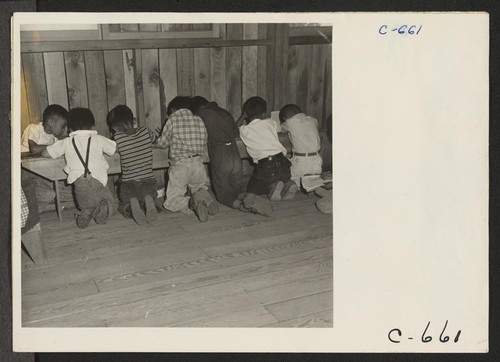 Manzanar, Calif.--Third grade students working on their arithmetic lesson at this first volunteer elementary school. School equipment was not yet available at the time this photograph was taken. Photographer: Lange, Dorothea Manzanar, California
