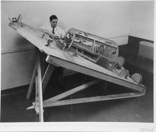 Theodore Dunham standing beside his spectrograph at California Institute of Technology, Pasadena