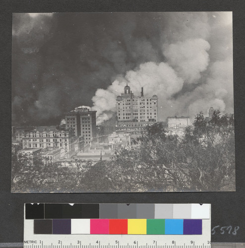 [Fires burning in Wholesale and Financial Districts. Looking east from Nob Hill. Merchants' Exchange Building, center.]