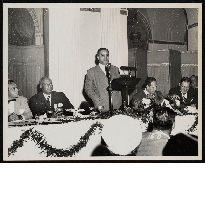 Ralph Bunche delivering speech with A. Philip Randolph (left), Vincent Impellitteri (right), Maurice Tobin seated