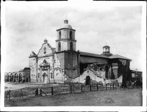 Exterior view of Mission San Luis Rey de Francia, showing the cemetery at right, California, 1900
