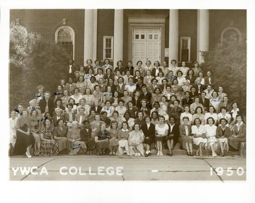 Group portrait of women sitting on the steps of a brick building