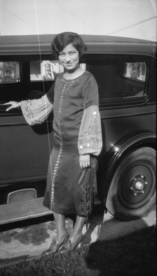 Young woman standing next to automobile
