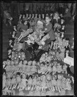 Santa Claus surrounded by baby dolls and two little girls, Los Angeles, 1938