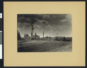 Sugar factory with a delivery of sugar beets, seen fron a distance, ca.1900