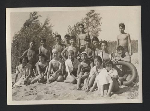 Photograph of Japanese individuals sitting on the beach