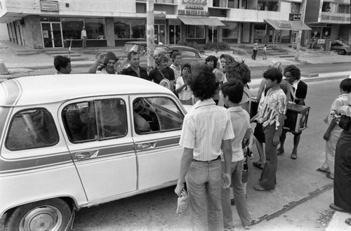 People performing near a car, Barranquilla, Colombia, 1977