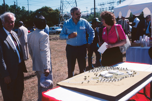 People standing around a model of the Contra Costa Campus