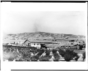 Exterior view of an asistencia of the Mission San Miguel Arcangel shown from a distance, ca.1931