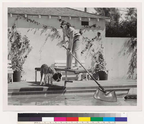 Bone overboard! [Judy Garland retrieving her dog's bone from swimming pool.]